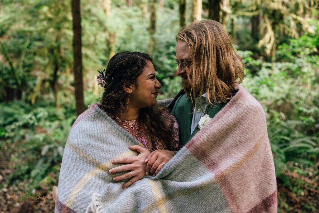 cozy bride and groom hugging under a blanket