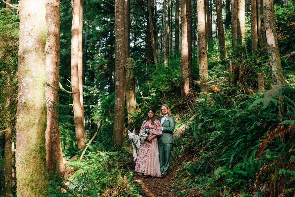 bride and groom and their dog at the rainforest trail surrounded by lush greenery