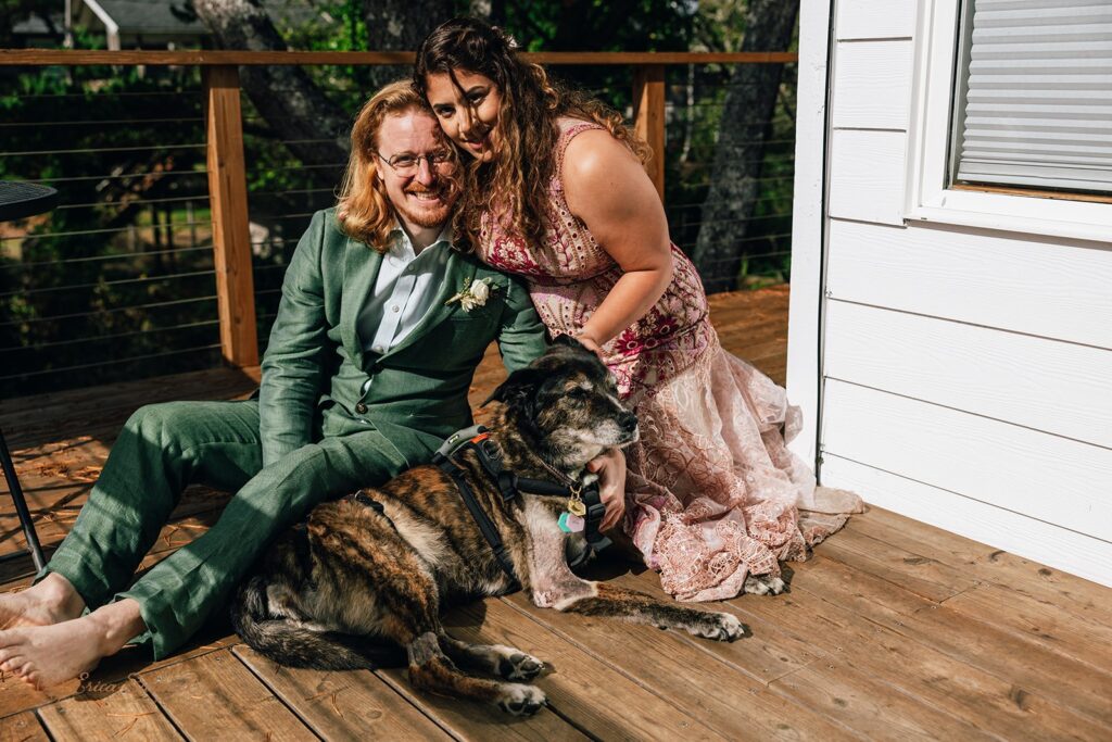 bride and groom cuddling their dog at their accommodation