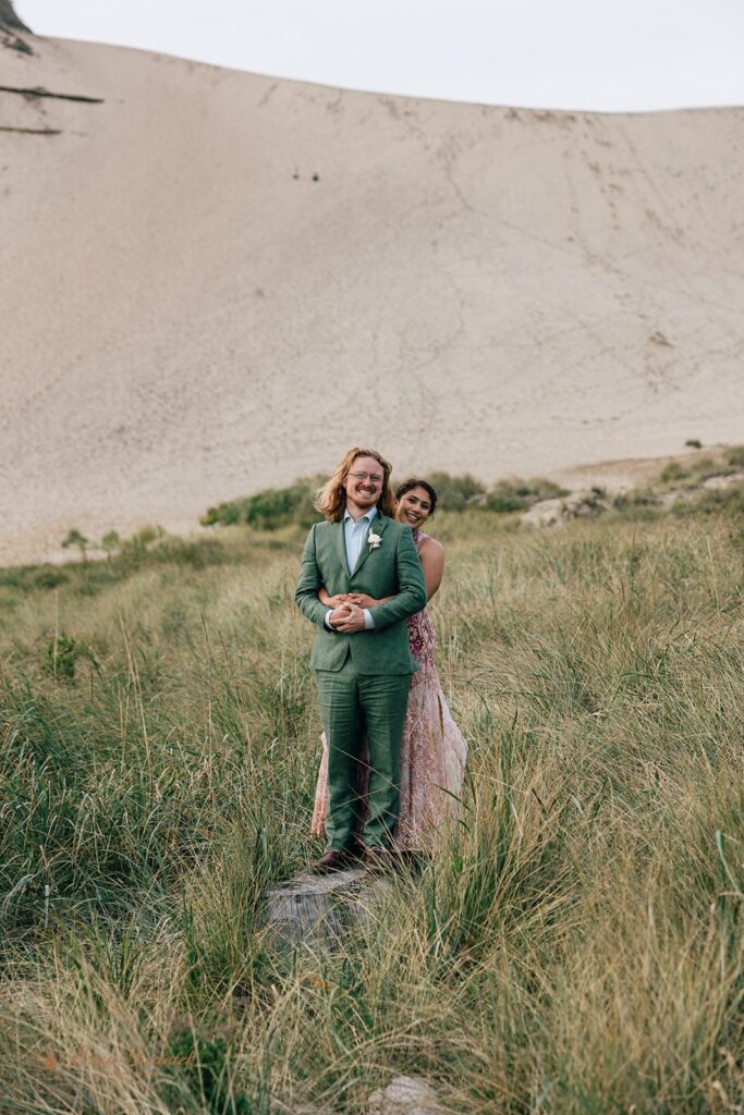 bride and groom hugging surrounded by coastal landscapes