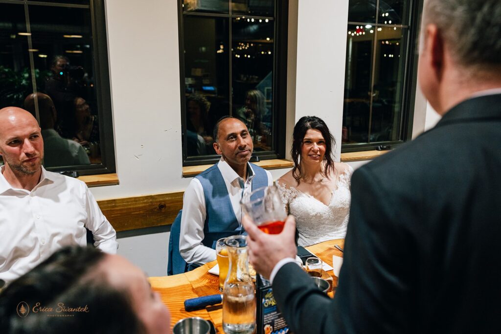 elopement couple and some guests enjoying a meal together at the brewery