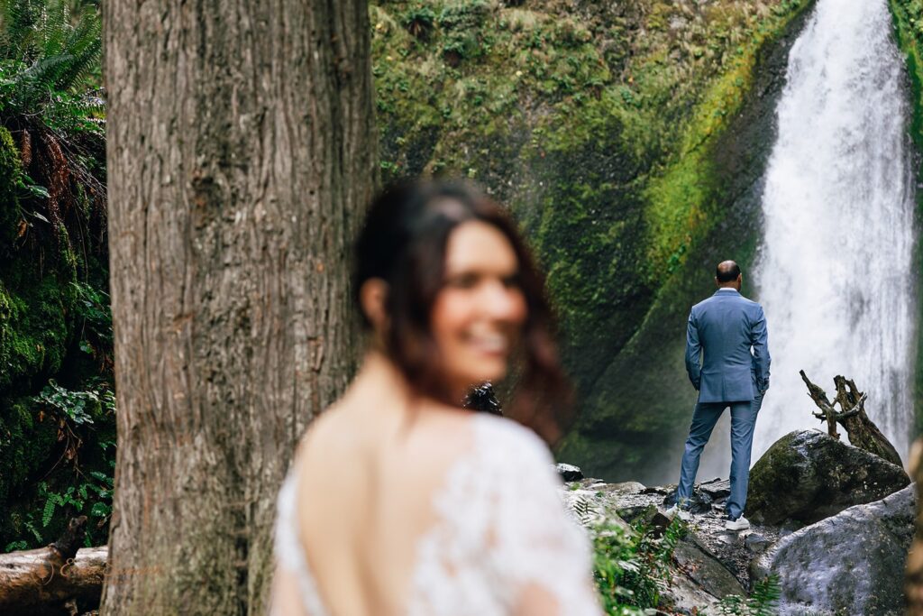 bride and groom first look by the waterfall during their waterfall elopement day