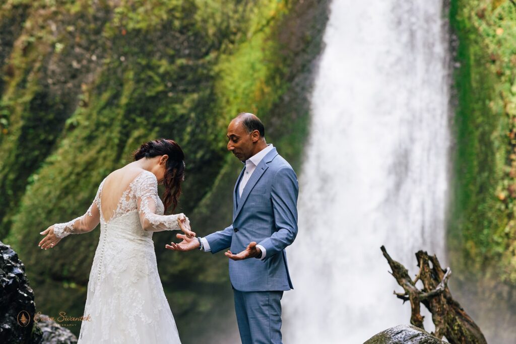 bride and groom first look by the waterfall during their waterfall elopement day