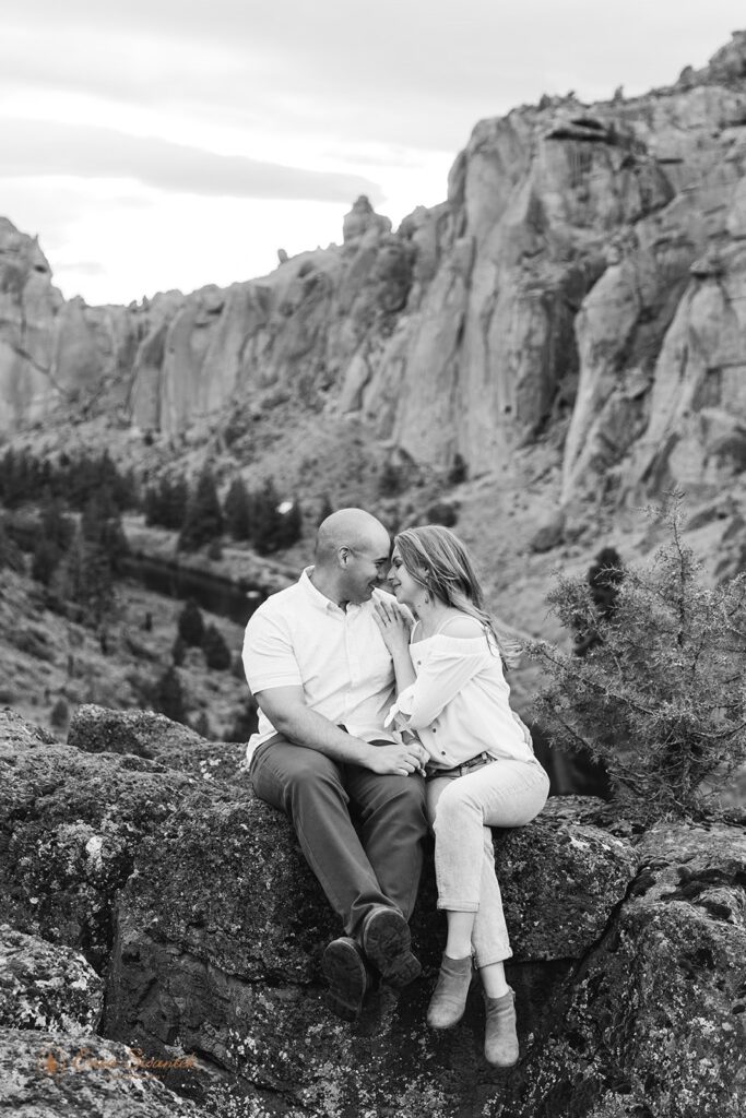 playful couple sitting on a rock during their session at smith rock state park