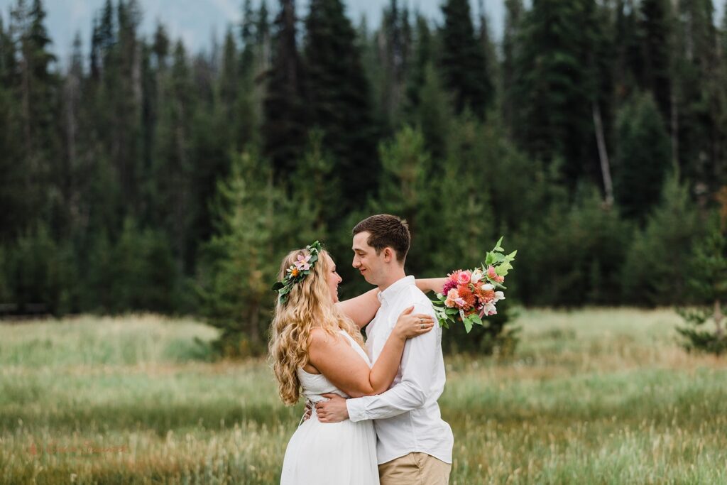 intimate elopement ceremony in a field with mountain backdrops at Sparks Lake 