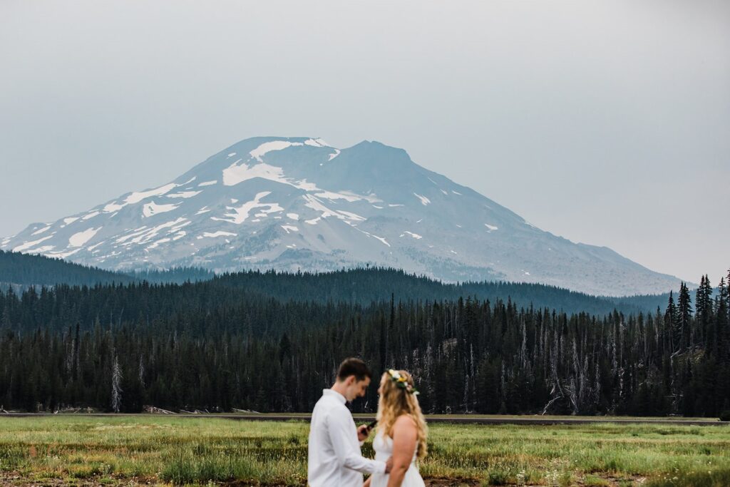 intimate elopement ceremony in a field with mountain backdrops at Sparks Lake 