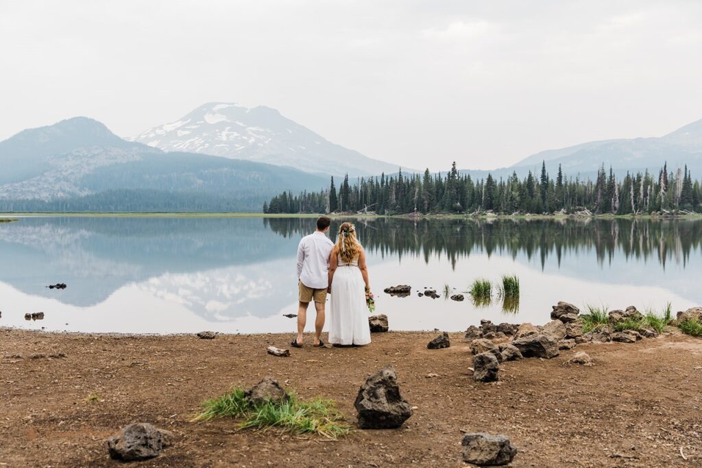 bride and groom standing at sparks lake shore gazing upon the stunning nature landscapes