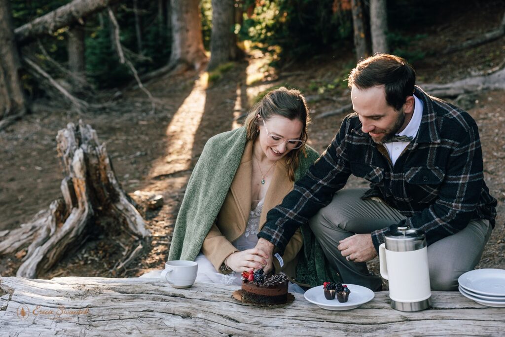 bride and groom cutting a small chocolate cake during their sparks lake elopement celebration