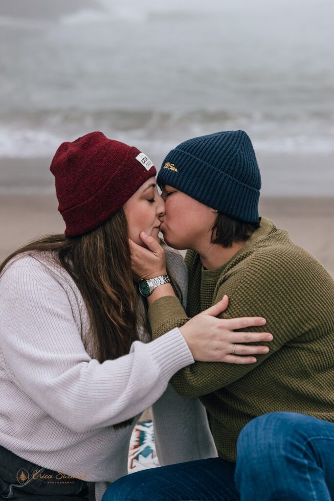 playful elopement couple sitting at the shore in oregon coast