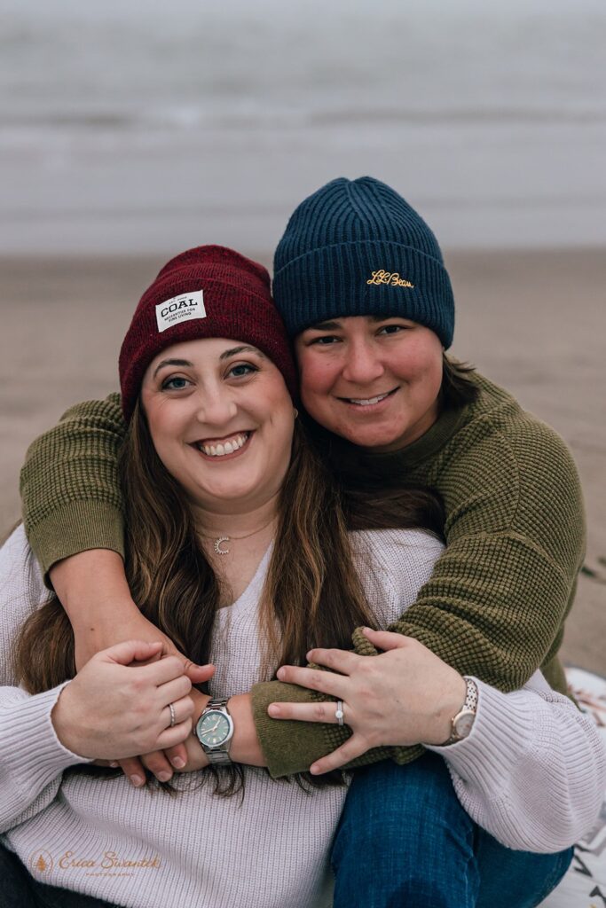 playful elopement couple sitting at the shore in oregon coast