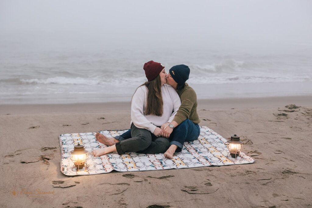 playful elopement couple sitting at the shore in oregon coast