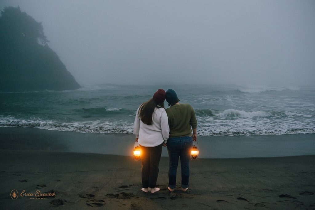 moody elopement couple with lanterns along oregon coast