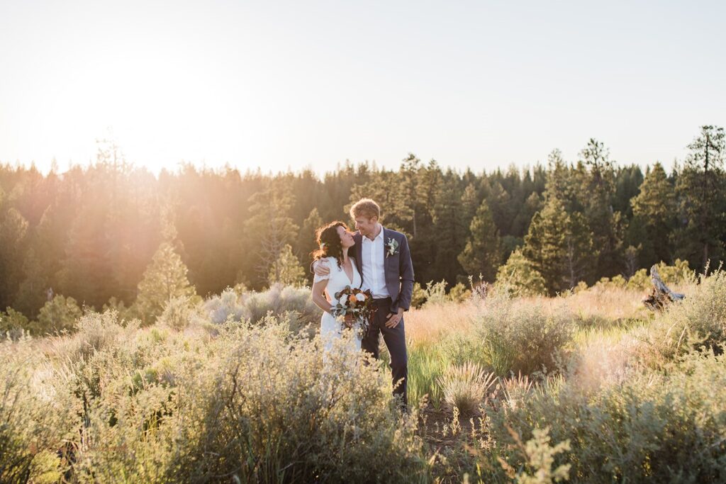 bride and groom roaming around a lush meadow in Shevlin Park with mountain and forest views in the backdrop