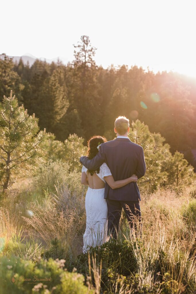 bride and groom roaming around a lush meadow in Shevlin Park with mountain and forest views in the backdrop