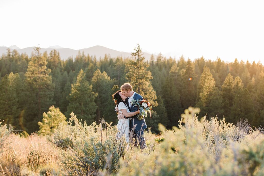 bride and groom roaming around a lush meadow in Shevlin Park with mountain and forest views in the backdrop