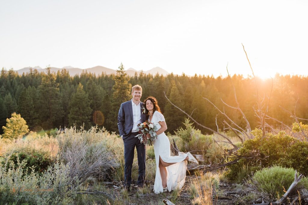 bride and groom roaming around a lush meadow in Shevlin Park with mountain and forest views in the backdrop