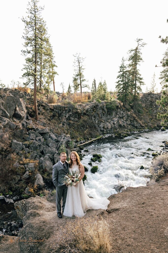 dreamy bride and groom moments by a wild running river at Dillon Falls