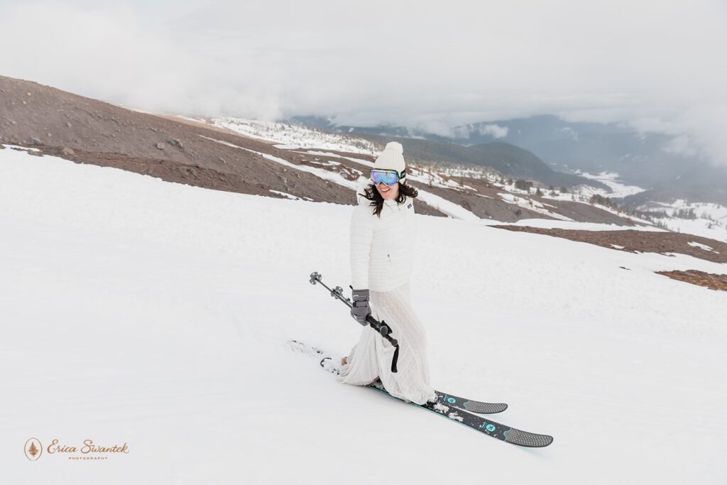 bride going down the mountain on skis during her winter elopement in mt. hood
