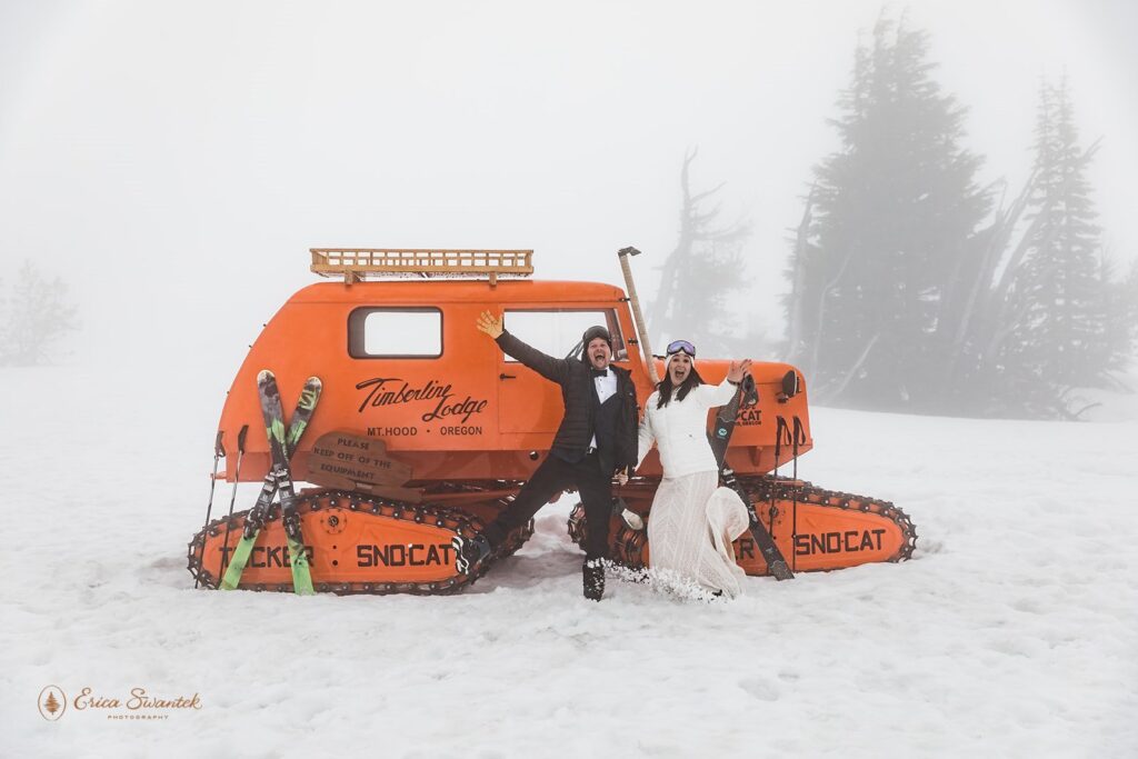elopement couple posing at a large orange sno cat during their winter elopement in mt. hood