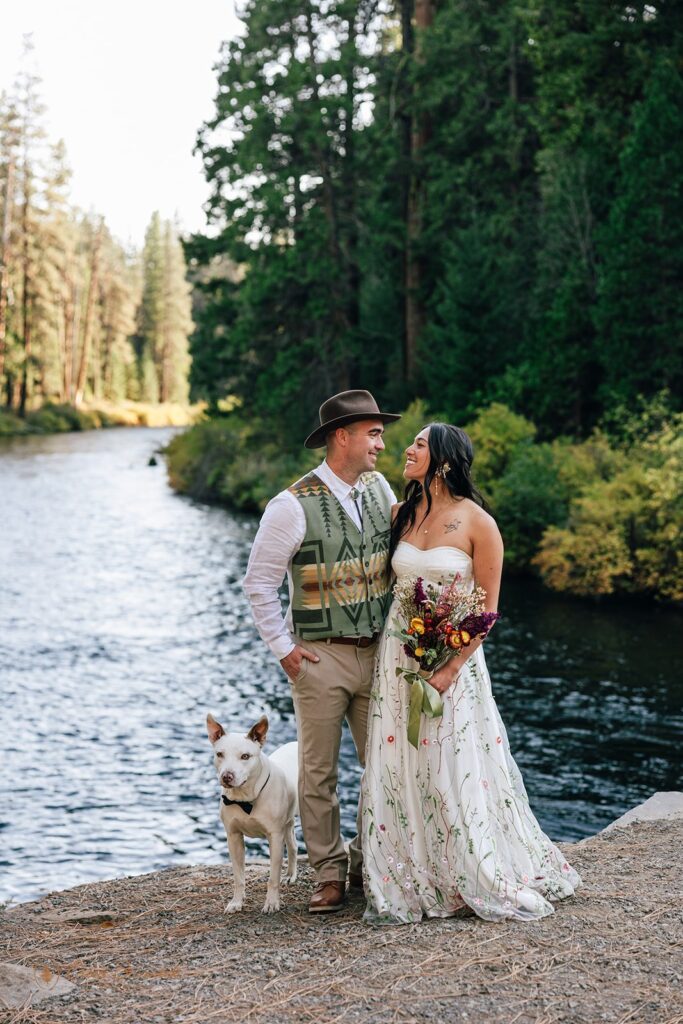 bride and groom posing with their pup during their Camp Sherman elopement in Oregon