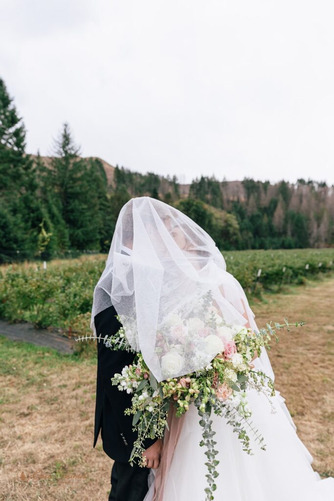 romantic bride and groom under veil in Oregon