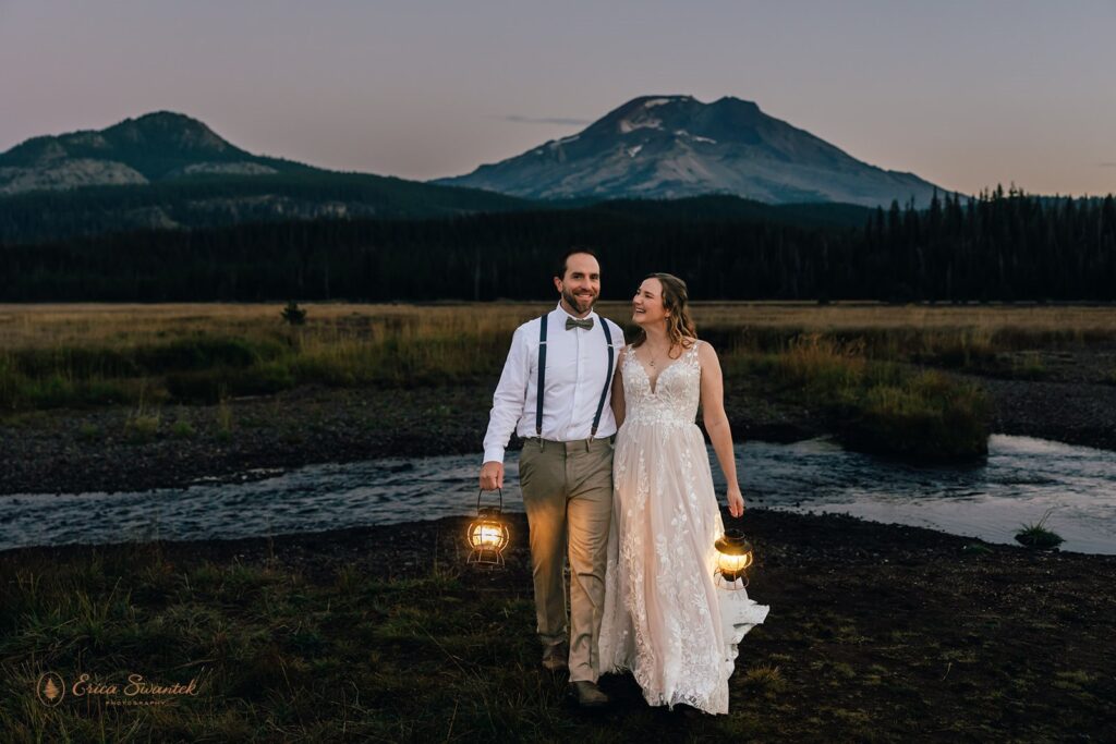 bride and groom walking around during dusk with lanterns