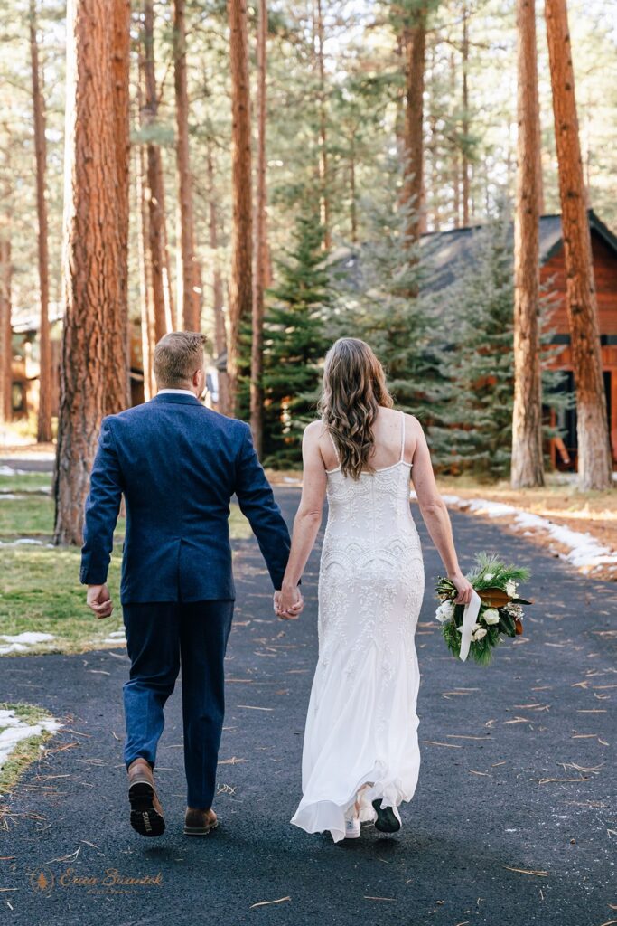 bride and groom roaming the forest together during their fivepine lodge elopement