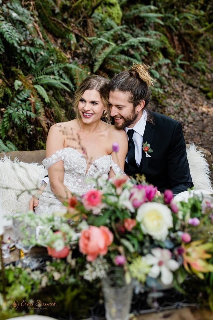 bride and groom sitting at a small wedding reception table set up outdoors during their belknap hot springs elopement