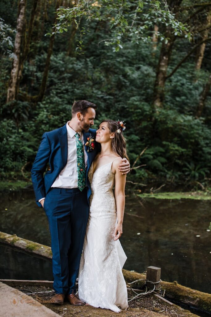 playful bride and groom roaming around lush woods during their Oregon forest elopement