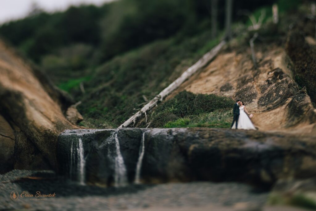 bride and groom in front of a small waterfall at oregon coast