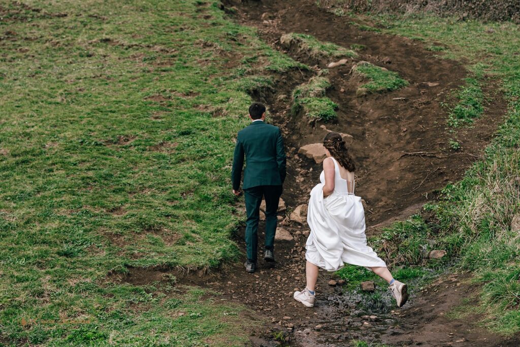 bride and groom walking the elk flats trail together during their oregon coast micro wedding day
