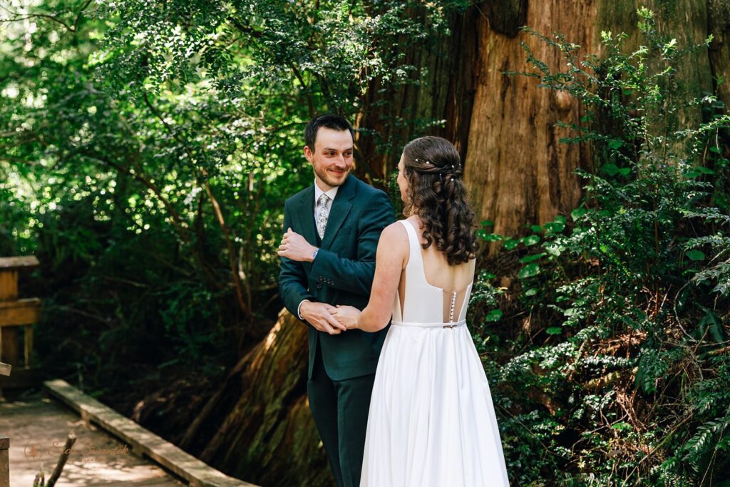 candid bride and groom first look in the forest during their oregon coast micro wedding day