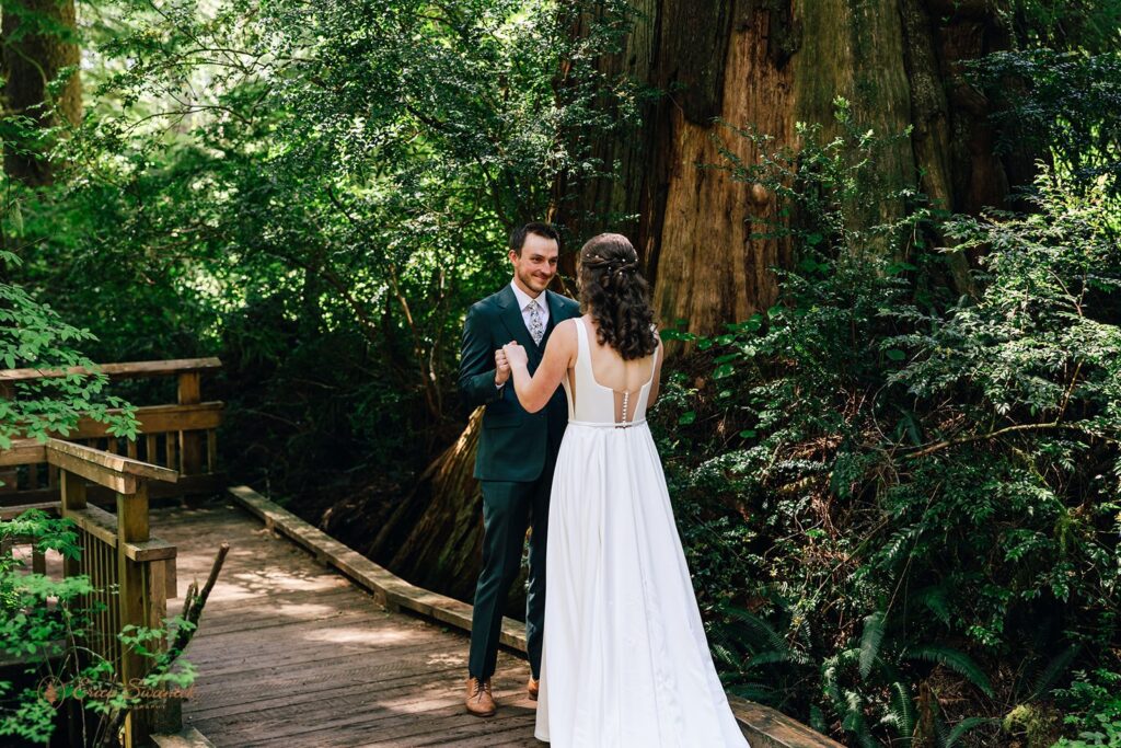 candid bride and groom first look in the forest during their oregon coast micro wedding day