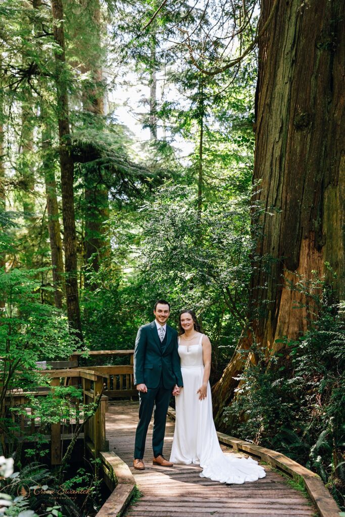 bride and groom walking a forest trail during their oregon coast micro wedding day