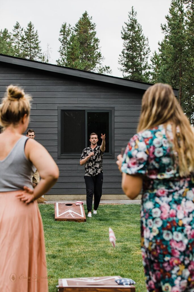 elopement couple and guests playing corn hole
