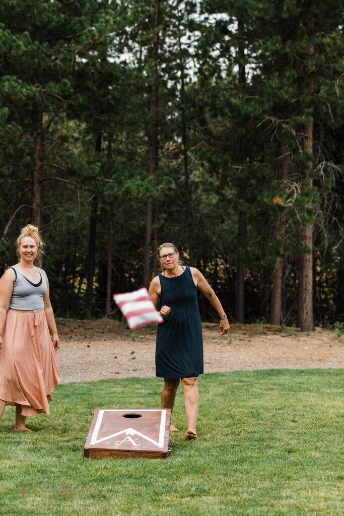 elopement couple and guests playing corn hole