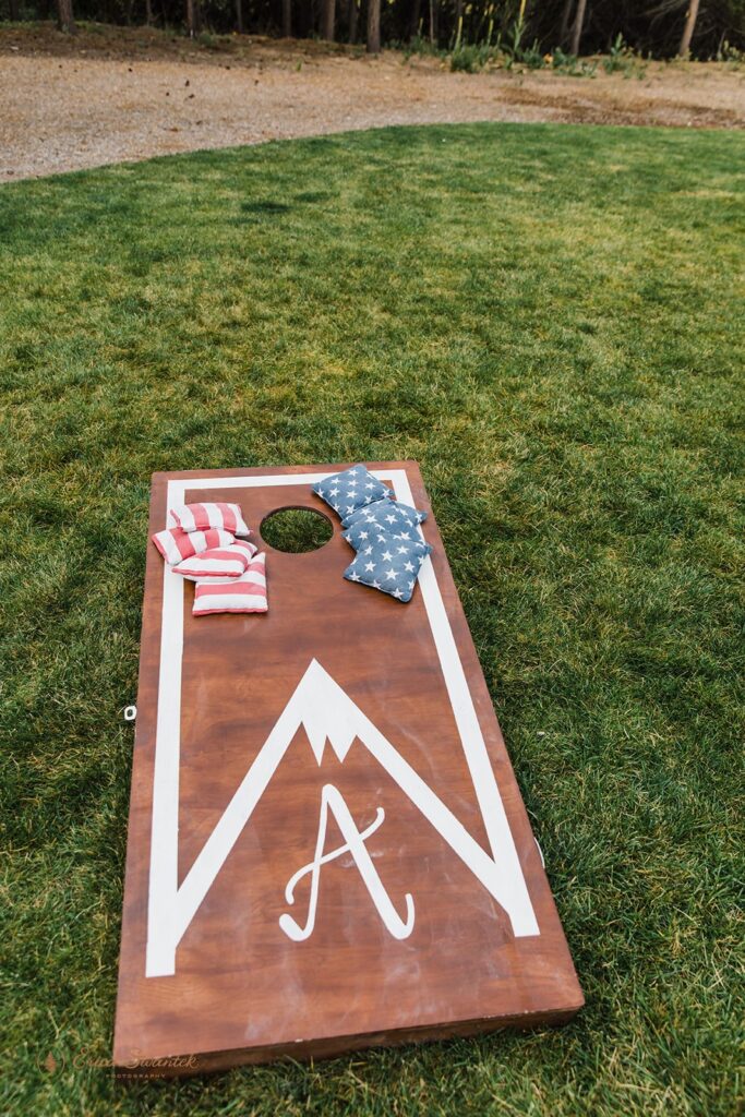 elopement couple and guests playing corn hole
