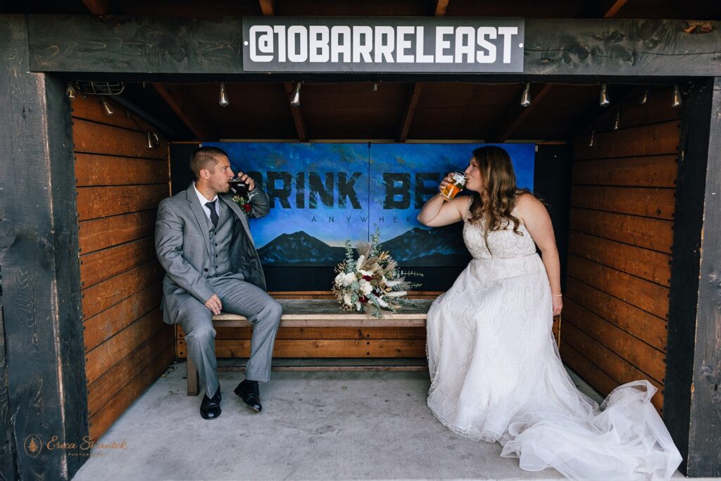 bride and groom enjoying beers at a brewery as they celebrate their elopement