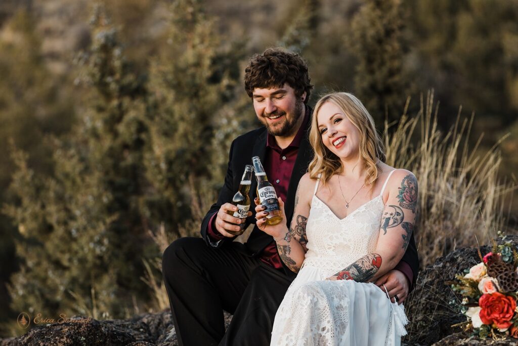 bride and groom toasting beers as they celebrate their elopement