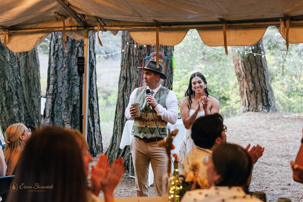 bride and groom delivering a speech during their cozy outdoor campground wedding reception