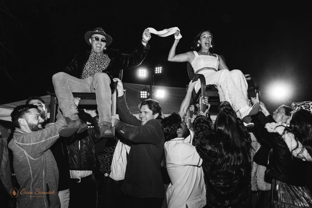 bride and groom being thrown in the air during the wedding reception