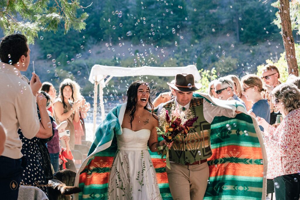 joyful newlywed ceremony exit while guests blow bubbles