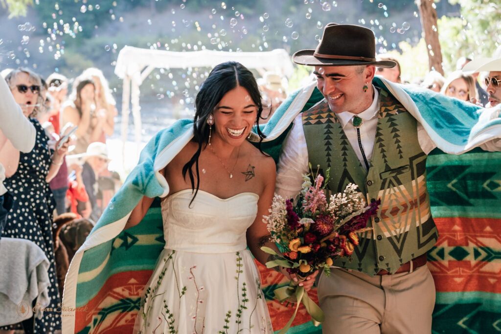 joyful newlywed ceremony exit while guests blow bubbles