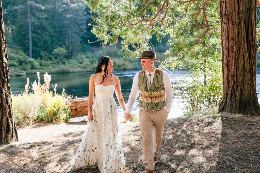 joyful newlyweds laughing and enjoying their time during their campground wedding along Metolius River