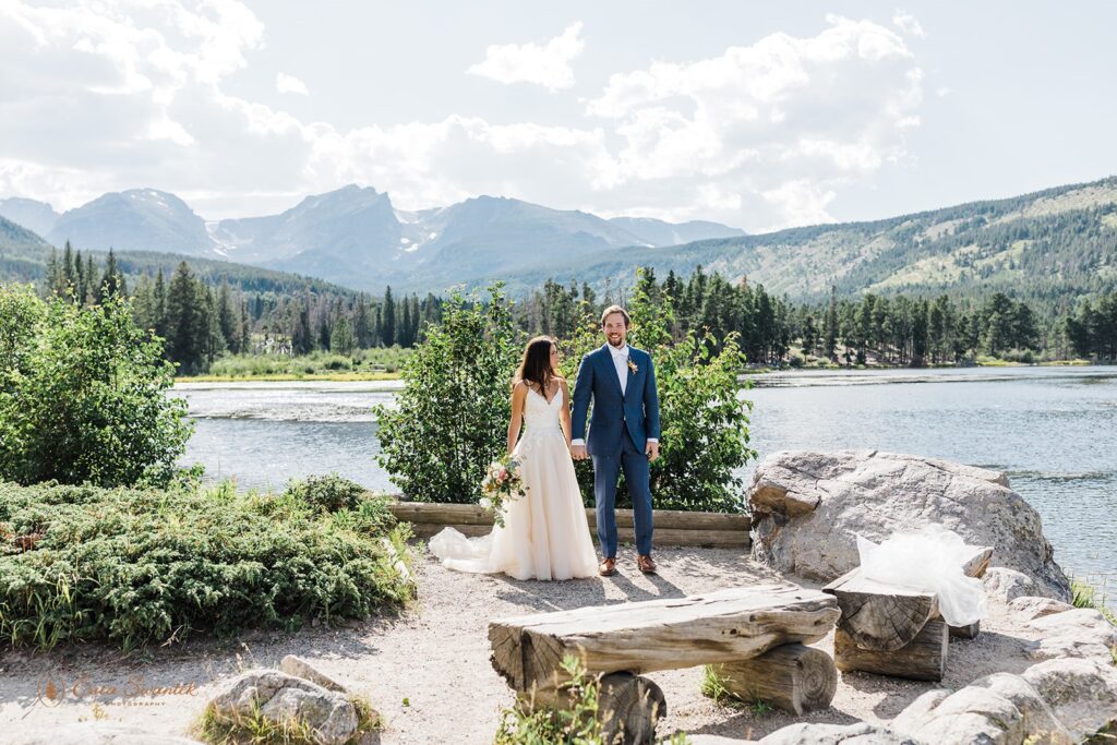 bride and groom walking hand in hand along a trail in sprague lake area in rocky mountain national park