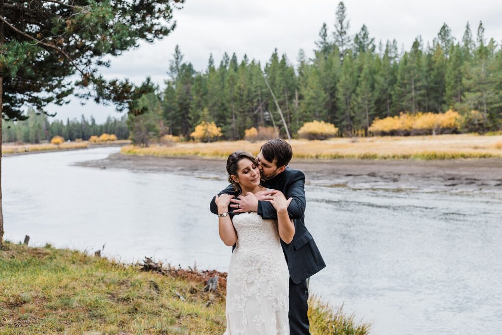 bride and groom posing outdoors next to Deschutes river