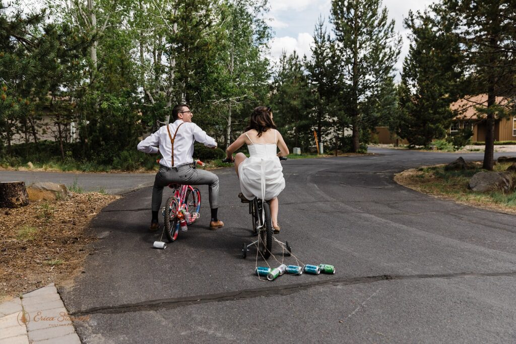 fun wedding couple riding small bikes celebrating their wedding day
