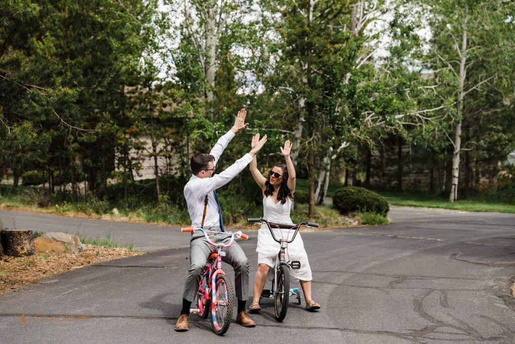 fun wedding couple riding small bikes celebrating their wedding day