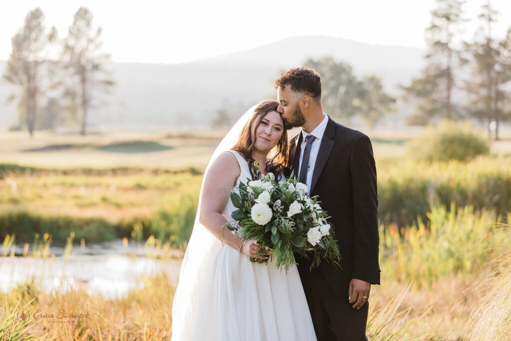 bride and groom standing surrounded by a lush field during their Sunriver Resort wedding day