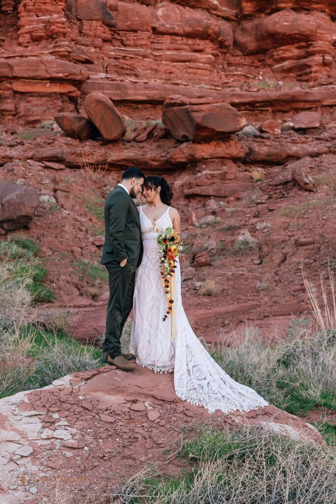 bride and groom in front of red rocks during their moab elopement in the desert